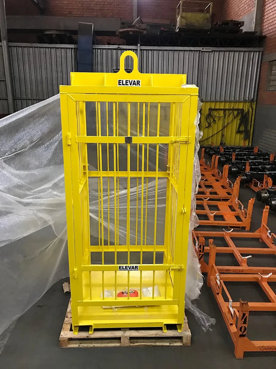Gaiola de içamento Elevar amarela com grade, porta e olhal de suspensão, sobre pallet em galpão